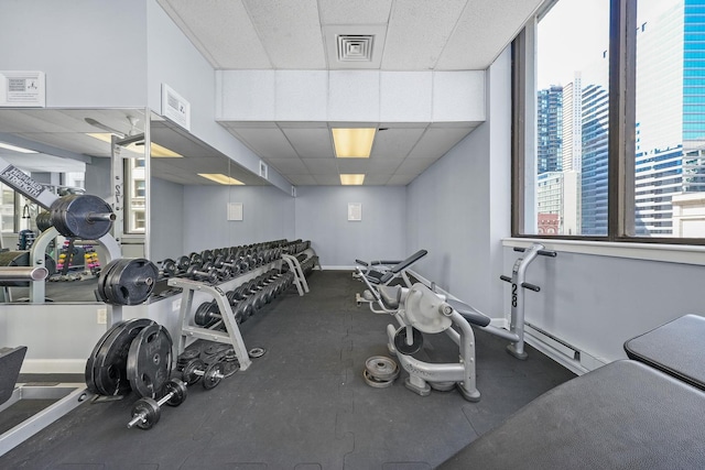exercise room featuring visible vents, baseboards, and a drop ceiling