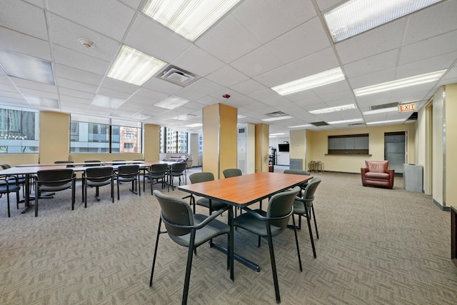 carpeted dining space featuring visible vents and a drop ceiling