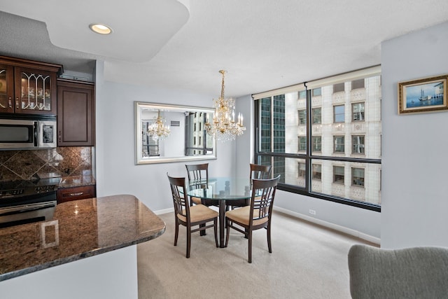 dining space with a chandelier, baseboards, light colored carpet, and recessed lighting