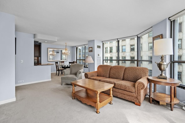 living area featuring baseboards, a chandelier, and light carpet