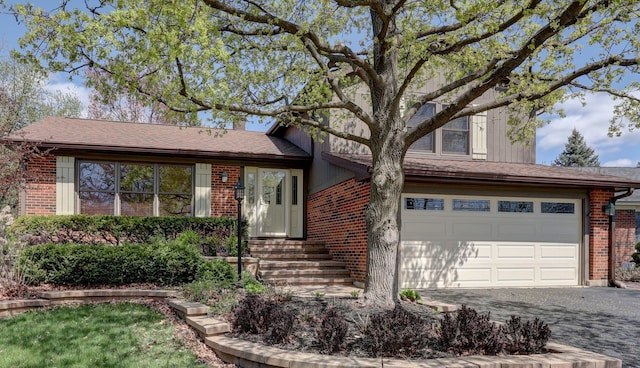 view of front facade with a garage, driveway, and brick siding