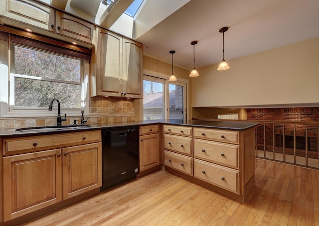 kitchen featuring a peninsula, tasteful backsplash, a sink, light wood-style flooring, and dishwasher