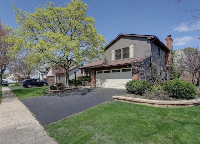 view of front of home with driveway, a chimney, a front yard, a garage, and brick siding