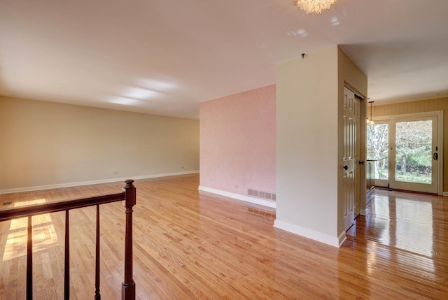 spare room featuring visible vents, light wood-style flooring, and baseboards