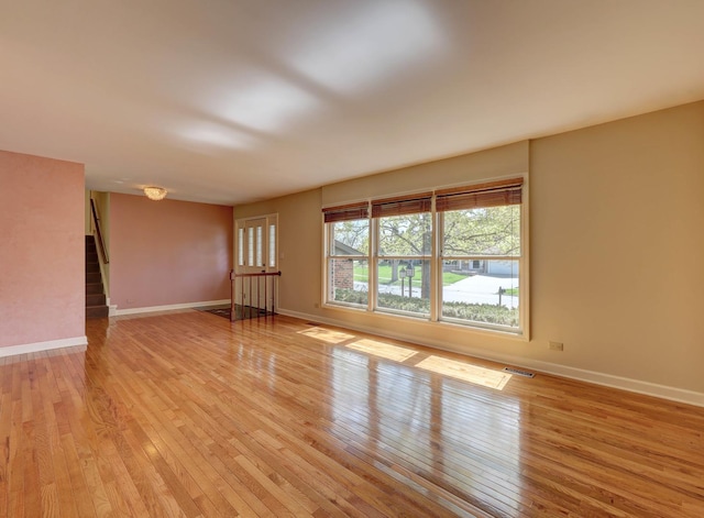 unfurnished room with baseboards and light wood-type flooring