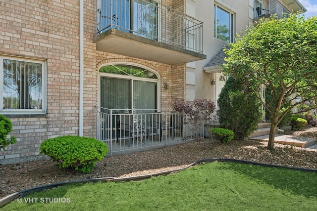 9439 S 79th Ave Unit 102, Hickory Hills, IL 60457 - doorway to property with brick siding, a balcony, and stucco siding