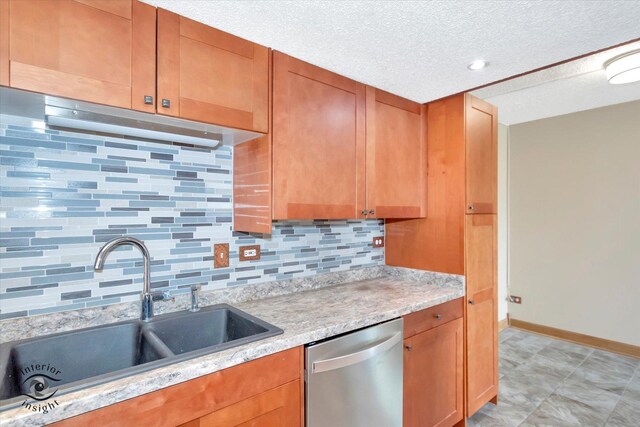 kitchen featuring stainless steel appliances, a sink, a textured ceiling, brown cabinets, and backsplash