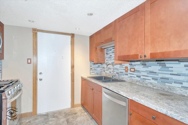 kitchen with stainless steel appliances, a sink, backsplash, baseboards, and a textured ceiling