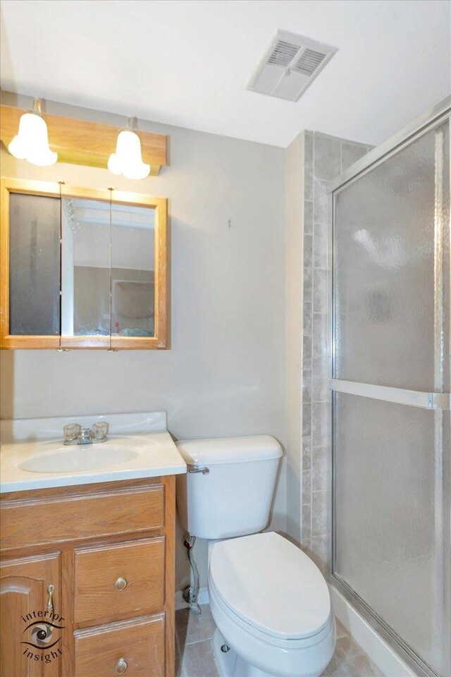 bathroom featuring a stall shower, vanity, toilet, and tile patterned floors