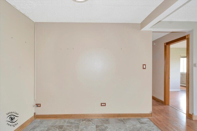 unfurnished room with baseboards