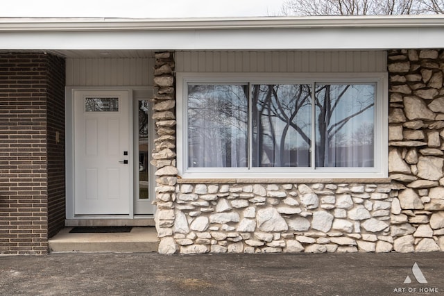 view of exterior entry with brick siding and stone siding
