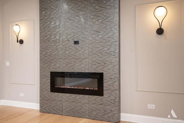 details featuring baseboards, wood finished floors, and a fireplace