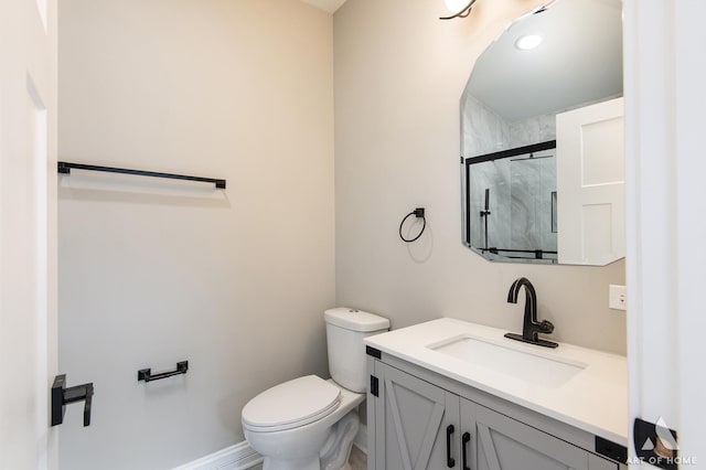 full bath featuring vanity, baseboards, a stall shower, and toilet