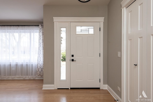 foyer featuring baseboards and wood finished floors