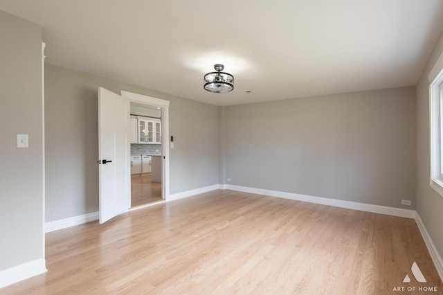 unfurnished room with baseboards and light wood finished floors