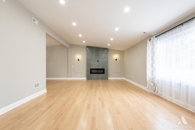 unfurnished living room with visible vents, recessed lighting, light wood finished floors, and vaulted ceiling