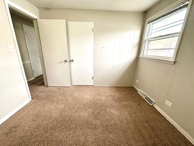 unfurnished bedroom featuring visible vents, baseboards, and carpet floors