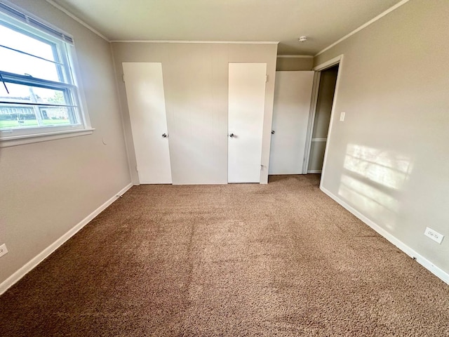 unfurnished bedroom featuring baseboards, ornamental molding, and carpet flooring