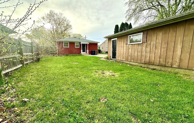 view of yard with central AC unit and fence