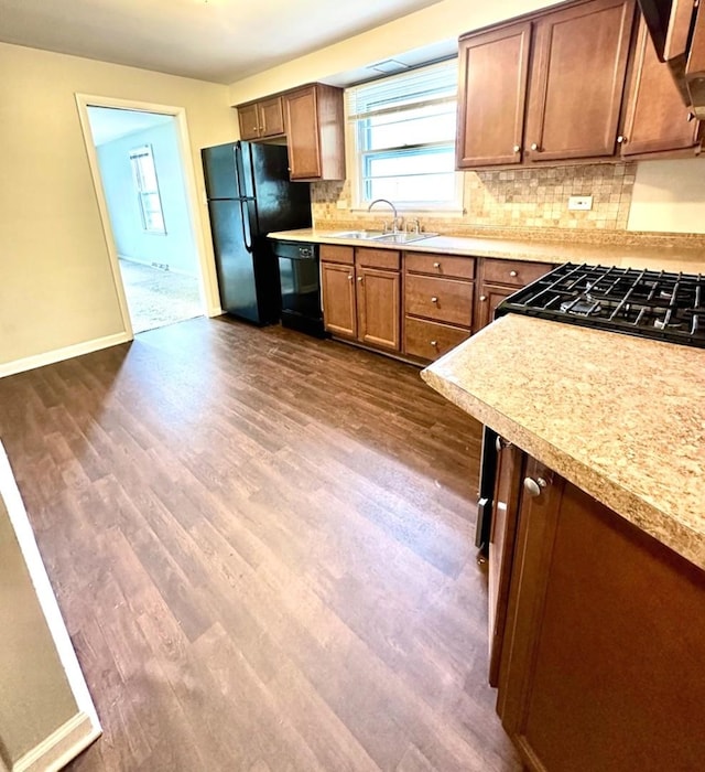 kitchen featuring a sink, black appliances, and dark wood-type flooring