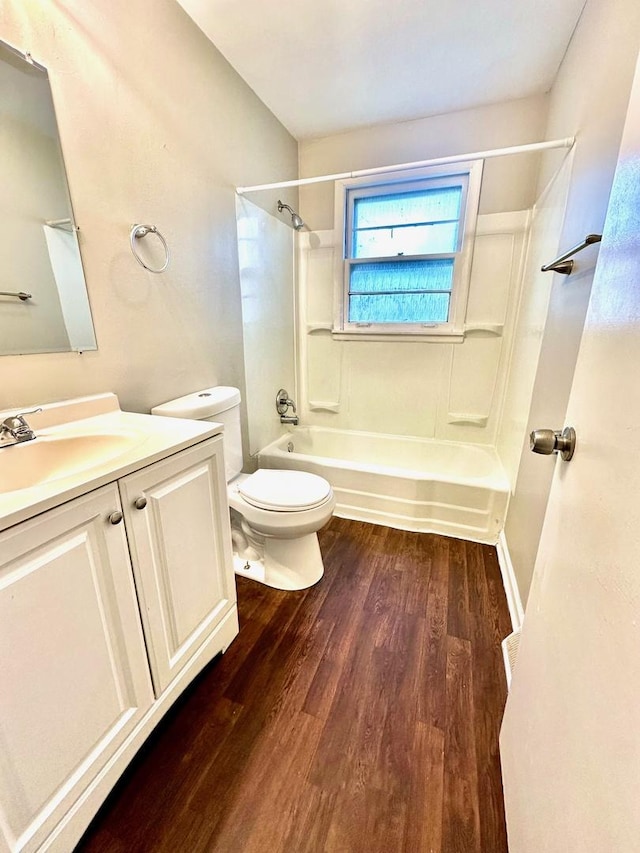 bathroom featuring toilet, shower / tub combination, wood finished floors, and vanity