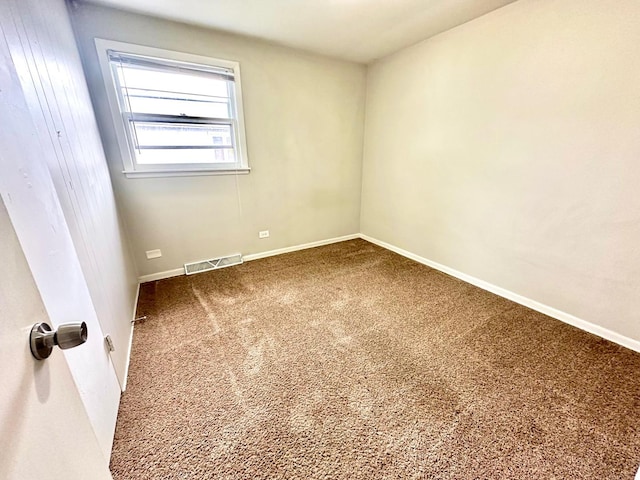 carpeted empty room featuring baseboards and visible vents