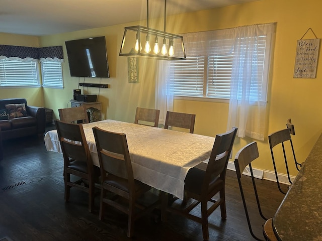 dining area with a healthy amount of sunlight and dark wood-type flooring