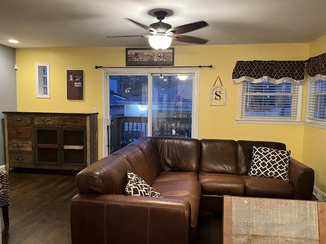 living area featuring baseboards, a ceiling fan, and wood finished floors