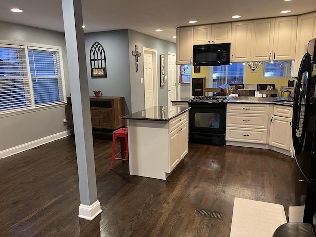 kitchen featuring dark wood finished floors, black appliances, and white cabinetry