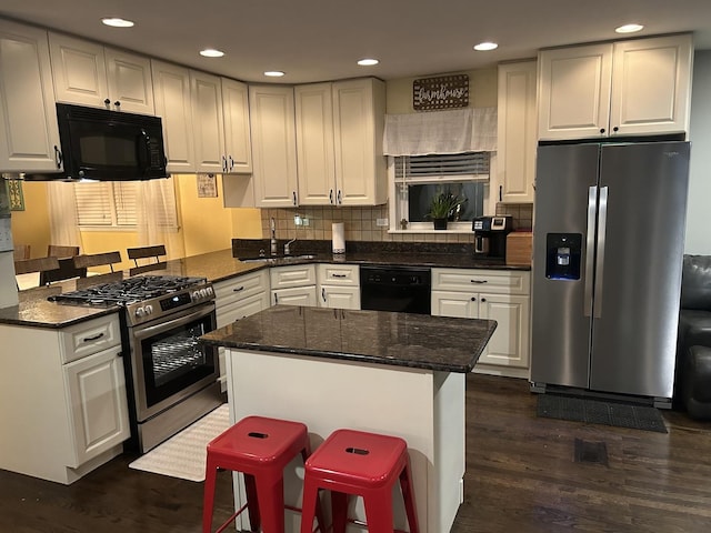 kitchen featuring a center island, white cabinetry, dark wood-type flooring, backsplash, and black appliances