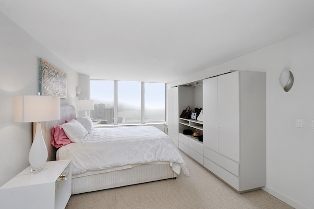 bedroom with baseboards and light colored carpet