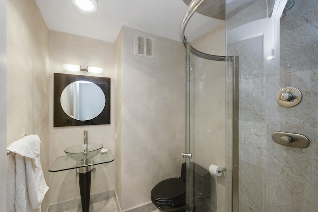 bathroom featuring toilet, visible vents, a shower stall, and a sink