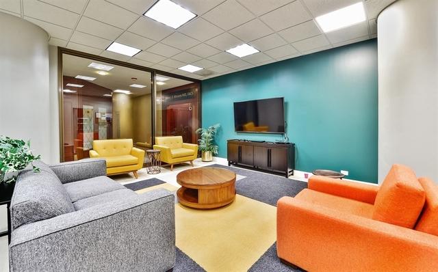 living room featuring carpet flooring and a drop ceiling