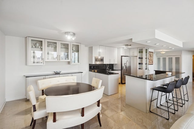 505 N Lake Shore Dr Unit 4412, Chicago, IL 60611 - kitchen with appliances with stainless steel finishes, a kitchen bar, dark countertops, a kitchen island, and white cabinetry