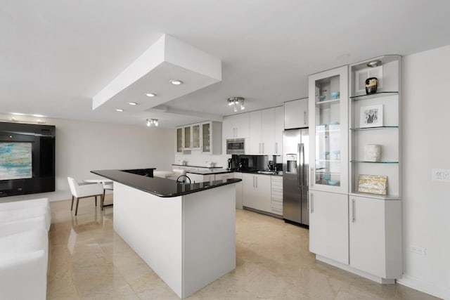kitchen with glass insert cabinets, white cabinetry, dark countertops, and stainless steel appliances