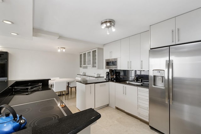 kitchen featuring a sink, glass insert cabinets, dark countertops, and stainless steel appliances