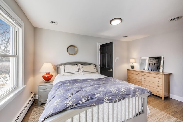 360 W Maple St, Lombard, IL 60148 - bedroom with visible vents, a baseboard radiator, wood finished floors, and multiple windows
