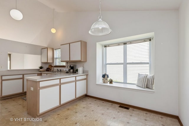 7 N Brittany Ln, Hainesville, IL 60030 - kitchen with a peninsula, lofted ceiling, light floors, light countertops, and pendant lighting
