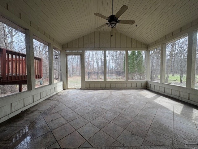 unfurnished sunroom featuring ceiling fan, a healthy amount of sunlight, and lofted ceiling