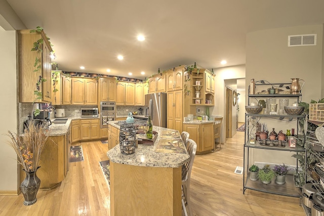 kitchen featuring open shelves, a sink, light wood-style floors, stainless steel appliances, and a kitchen island