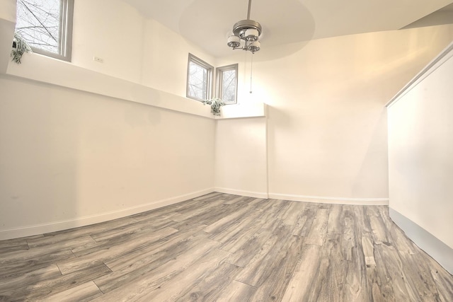 additional living space featuring baseboards and wood finished floors