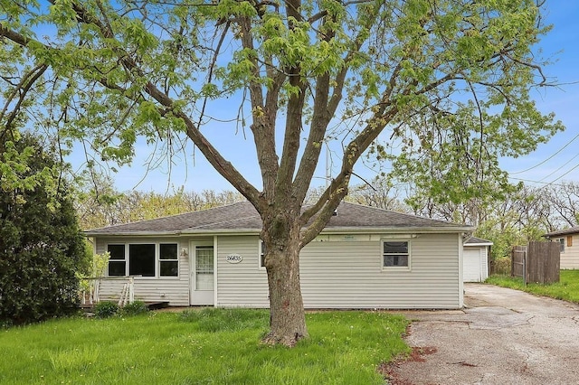 back of house featuring concrete driveway, a garage, and roof with shingles