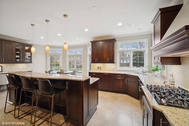 kitchen featuring a sink, a healthy amount of sunlight, ornamental molding, and black gas cooktop