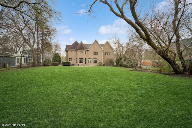 rear view of property featuring a yard