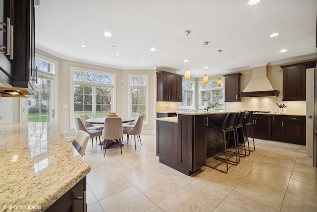kitchen featuring a kitchen island, crown molding, dark brown cabinets, custom range hood, and recessed lighting
