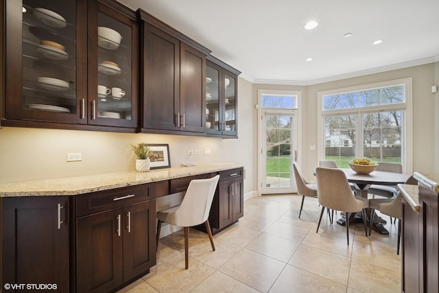 interior space featuring crown molding, light tile patterned floors, baseboards, and a wealth of natural light