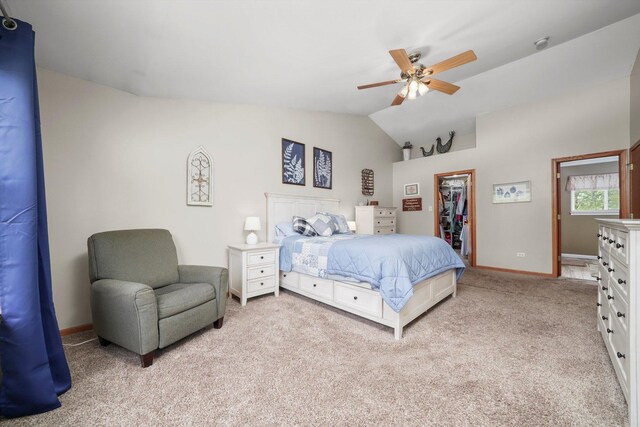 bedroom featuring a walk in closet, a ceiling fan, vaulted ceiling, baseboards, and light carpet