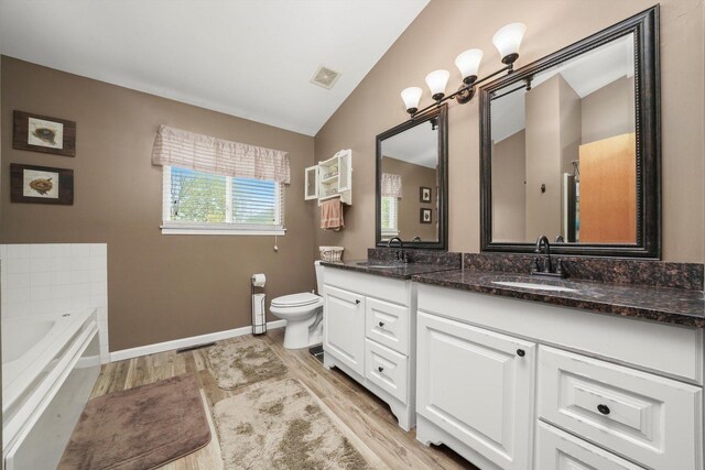 full bathroom with a sink, toilet, wood finished floors, and visible vents