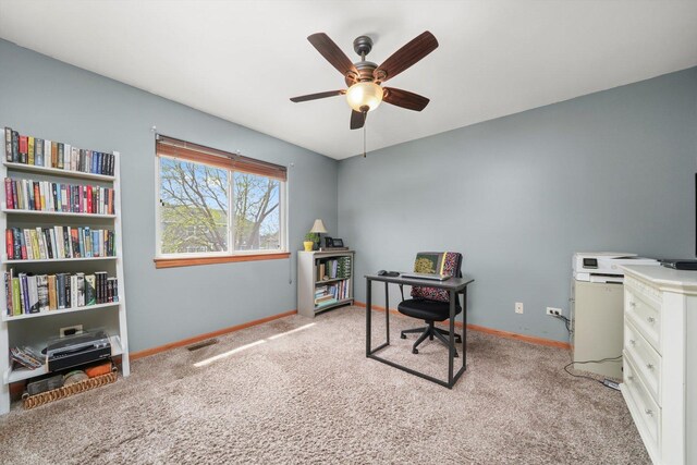 home office featuring baseboards, ceiling fan, and light carpet