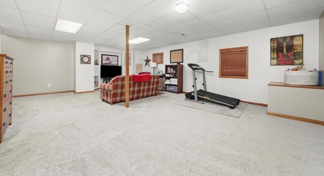 exercise area featuring carpet floors, a paneled ceiling, and baseboards